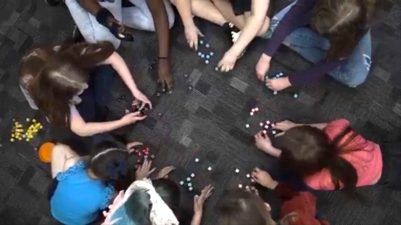 A group of children play with sets of die.